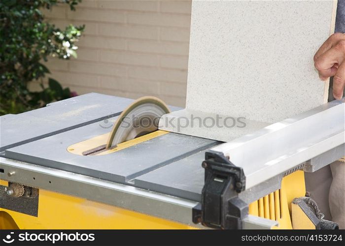 Carpenter uses a table saw to cut laminate counter top.