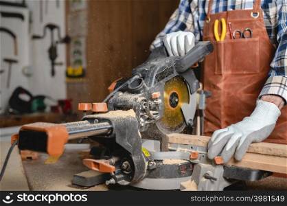 Carpenter using an electric circular saw, cutting piece of wood. High quality photo.. Carpenter using an electric circular saw, cutting piece of wood.