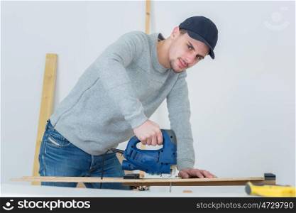 carpenter using an electric saw to cut wood