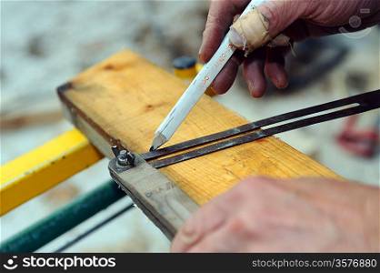Carpenter using set square to mark wood