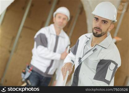 carpenter with apprentice in workshop
