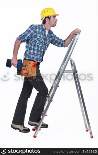 Carpenter with drill climbing step-ladder