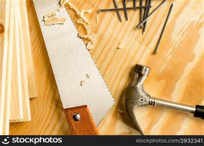 Carpenter wood saw, roofing hammer, nails and slats