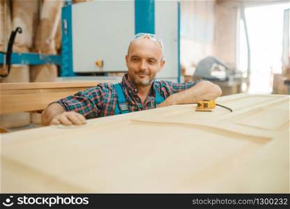 Carpenter, wooden door manufacturing, woodworking, lumber industry, carpentry. Wood processing on furniture factory, production of products of natural materials