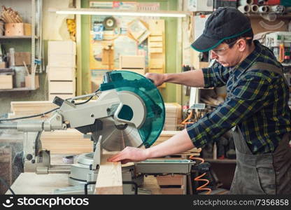 Carpenter worker cutting wooden board with circular saw. Profession, carpentry and woodwork concept.. Carpenter worker cutting wooden board
