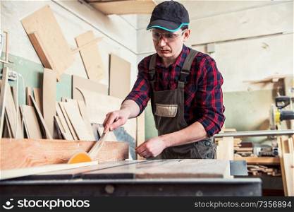Carpenter worker cutting wooden board with circular saw. Profession, carpentry and woodwork concept.. Carpenter worker cutting wooden board