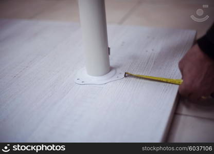 carpenter worker measuring distance for drilling holes in new furniture