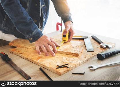 Carpenter working carefully looking at the plans work in carpentry. He is successful entrepreneur at his workplace. hammering a nail Supports On Building Site work with cutter. Carpenter working carefully looking at the plans work in carpent