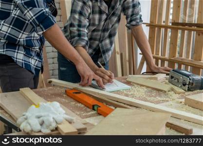 Carpenter working on wood craft at workshop to produce construction material or wooden furniture. The young Asian carpenter use professional tools for crafting. DIY maker and carpentry work concept.. Carpenter working on wood craft at workshop