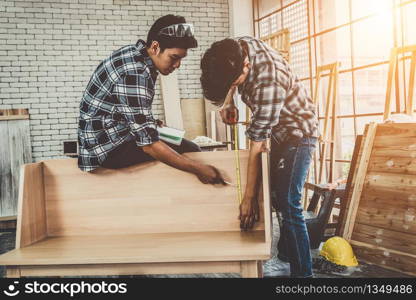 Carpenter working on wood craft at workshop to produce construction material or wooden furniture. The young Asian carpenter use professional tools for crafting. DIY maker and carpentry work concept.