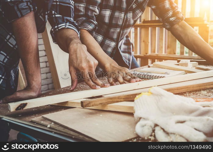 Carpenter working on wood craft at workshop to produce construction material or wooden furniture. The young Asian carpenter use professional tools for crafting. DIY maker and carpentry work concept.