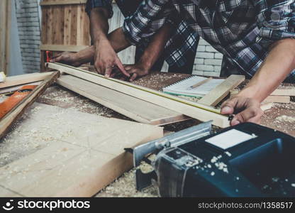 Carpenter working on wood craft at workshop to produce construction material or wooden furniture. The young Asian carpenter use professional tools for crafting. DIY maker and carpentry work concept.