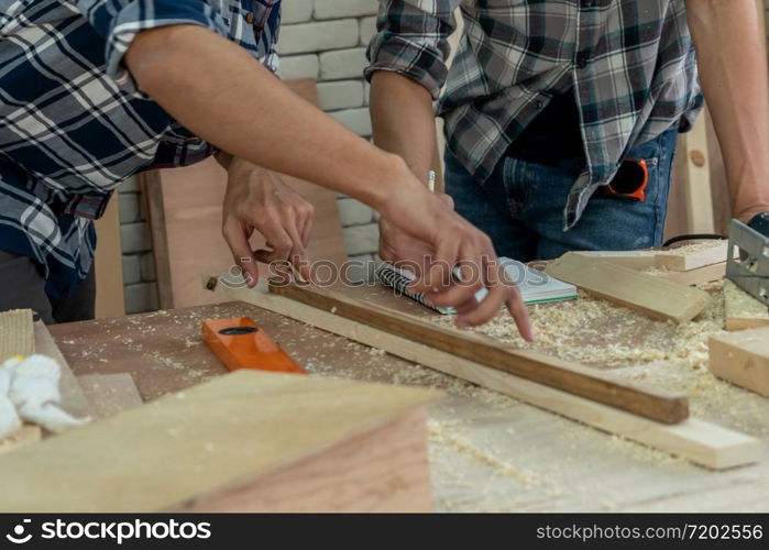 Carpenter working on wood craft at workshop to produce construction material or wooden furniture. The young Asian carpenter use professional tools for crafting. DIY maker and carpentry work concept.