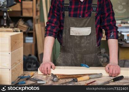 Carpenter working with a chisel and hammer in a wooden workshop. Carpenter working with a chisel
