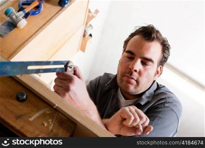 Carpenter working with angle and pencil in his workshop