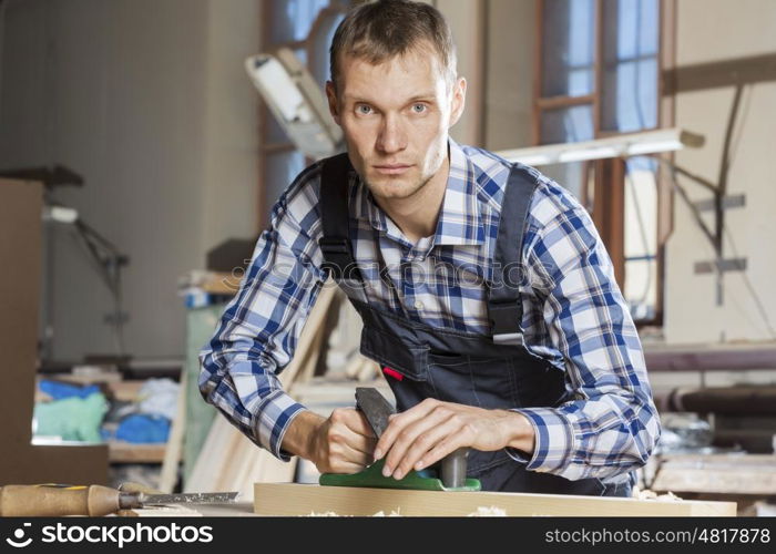 Carpenter working with plane in his studio. Carpenter at work