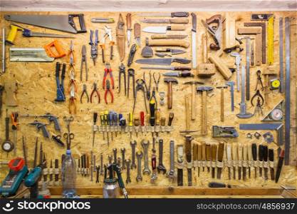 carpentry, woodwork and equipment concept - work tools hanging on wall at workshop
