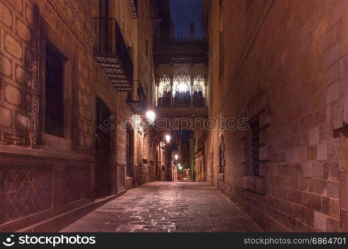 Carrer del Bisbe in Gothic Quarter, Barcelona. Cobbled medieval Carrer del Bisbe street with Bridge of Sighs in Barri Gothic Quarter at night, Barcelona, Catalonia, Spain