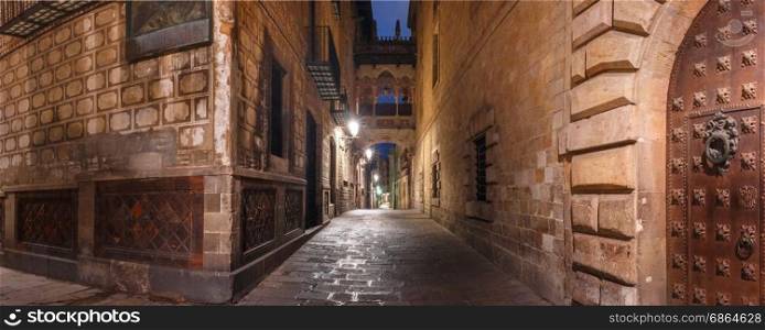 Carrer del Bisbe in Gothic Quarter, Barcelona. Panorama of cobbled medieval Carrer del Bisbe street with Bridge of Sighs in Barri Gothic Quarter at night, Barcelona, Catalonia, Spain