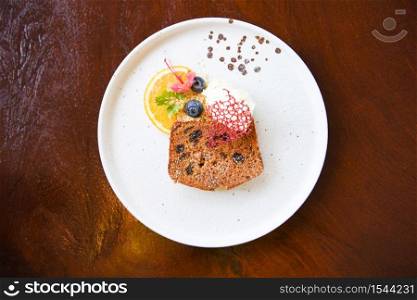Carrot Cake on white plate / Homemade dessert delicious cake with orange blueberry and icing sugar on wood background