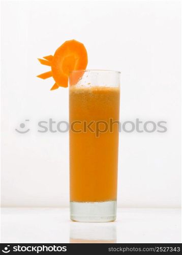 carrot drink in a glass with ice and a slice of carrot. drink isolated on white background. fruit drinks in a glass