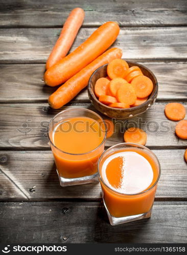 Carrot juice and pieces of carrots in a bowl. On wooden background. Carrot juice and pieces of carrots in a bowl.