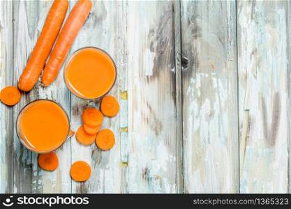 Carrot juice in a glass Cup. On wooden background. Carrot juice in a glass Cup.
