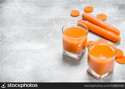 Carrot juice in a glass. On rustic background. Carrot juice in a glass.
