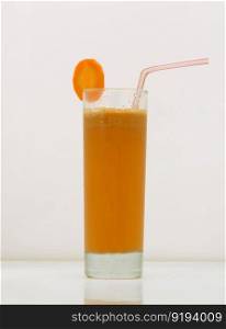 carrot juice in a glass with a straw and a slice of carrot. drink isolated on white background. fruit drinks in a glass