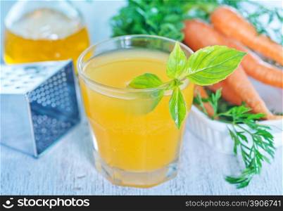 carrot juice in glass and on a table