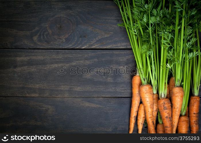 Carrots on wooden table background. Copy space. Top view