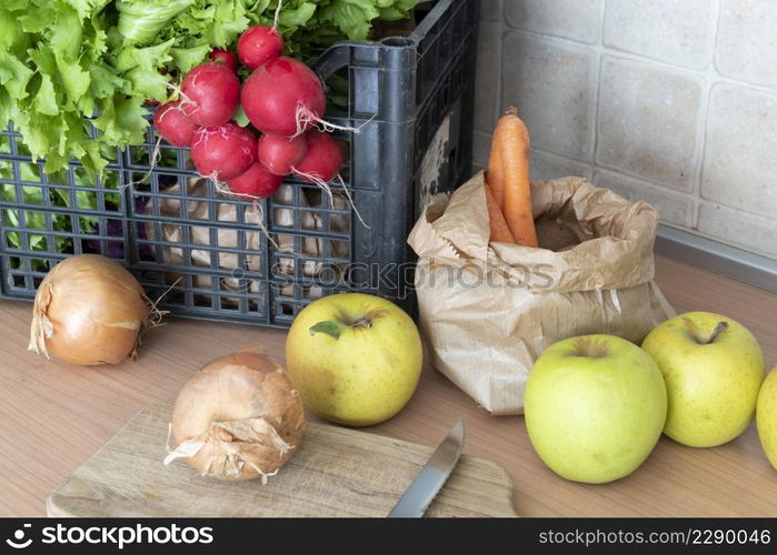 carrots organic vegetable in paper sachet, apples, radish and onions