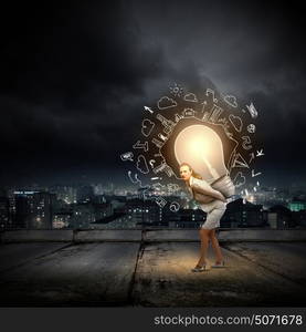 Carrying out an idea. Young businesswoman carrying light bulb on back