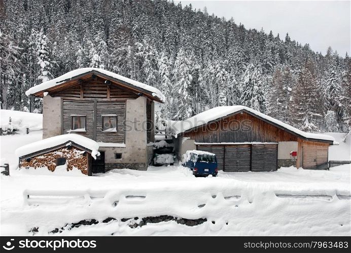 Cars, deep in snow, beside a alpine house, in Western Switzerland