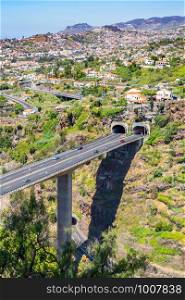 Cars driving on highway and overpass with two tunnels at Madeira in country Portugal