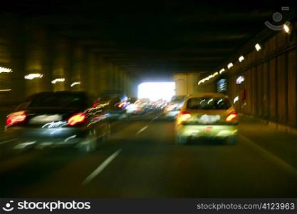 Cars moving traffic with brurred blur headlights on the tunnel