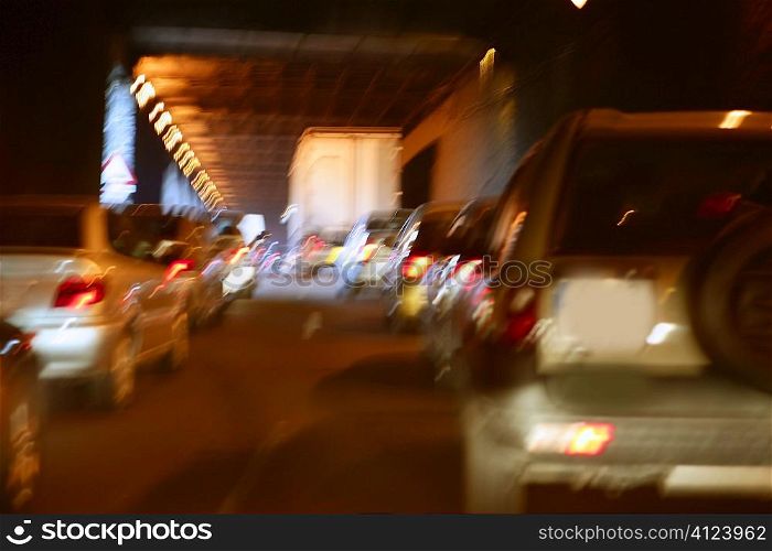 Cars moving traffic with brurred motion headlights on the tunnel