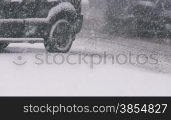 Cars on slippery road in blizzard.