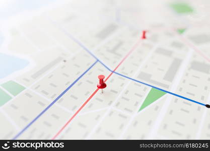 cartography, location and navigation concept - close up of map or city plan with pin