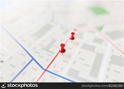 cartography, location and navigation concept - close up of map or city plan with pin