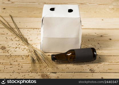 carton box beer bottle ears wheat wooden surface