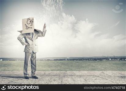 Carton head. Businessman wearing carton box with drawn emotions on head