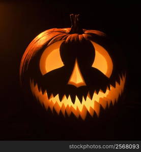 Carved Halloween pumpkin glowing in the dark.