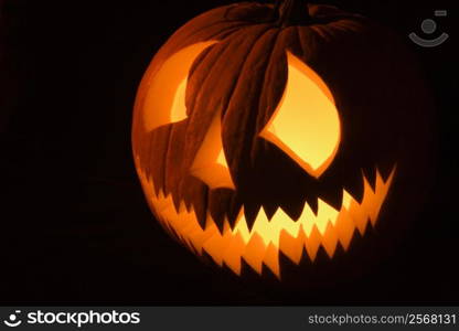 Carved Halloween pumpkin glowing in the dark.