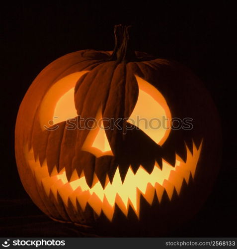 Carved Halloween pumpkin glowing in the dark.