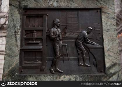 Carved plaques on the side of the Benjamin Franklin statue in Boston, Massachusetts, USA