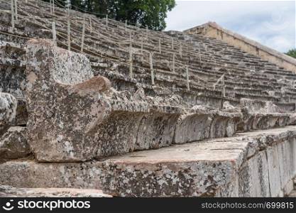 Carved seat in the theater of the Sanctuary of Asklepios at Epidaurus. Massive amphitheatre at Sanctuary of Asklepios at Epidaurus Greece