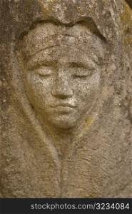 Carving of face in stone