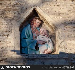 Carving of Jesus and child in an old wall in Tallinn Estonia on the climb to Toompea