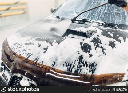 Carwash service, car cleaning, top view on hood. Auto detailing, washing foam off. Carwash service, car cleaning, top view on hood